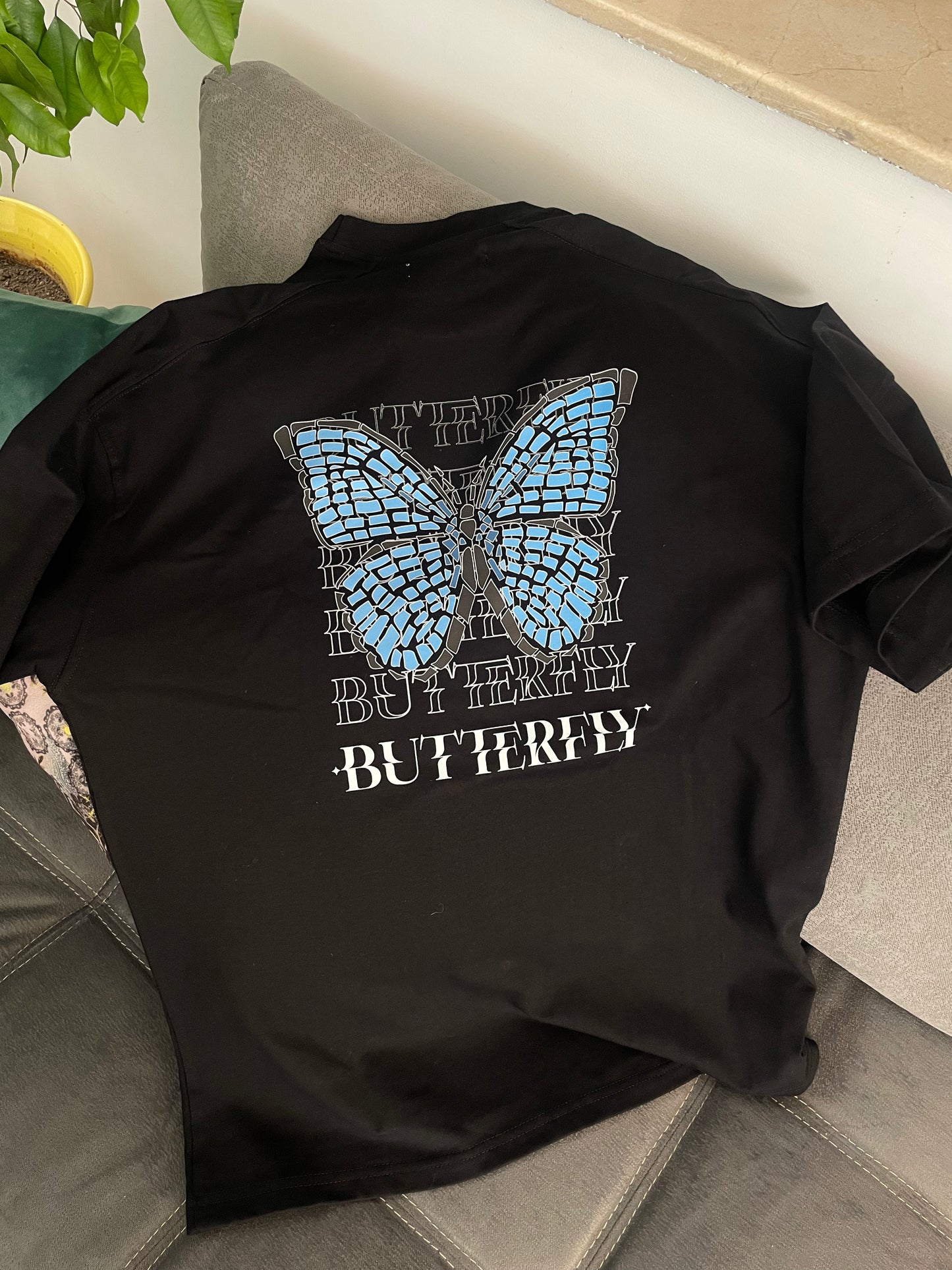 T-shirt oversize crème avec motif papillon stylisé, face avant